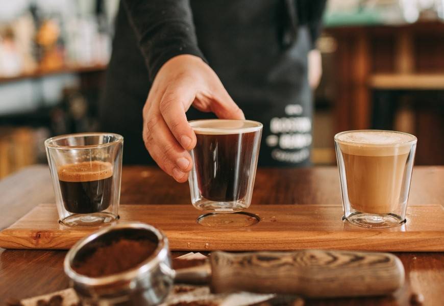 Boston Bean barista places down artisanal coffee on a tasting paddle