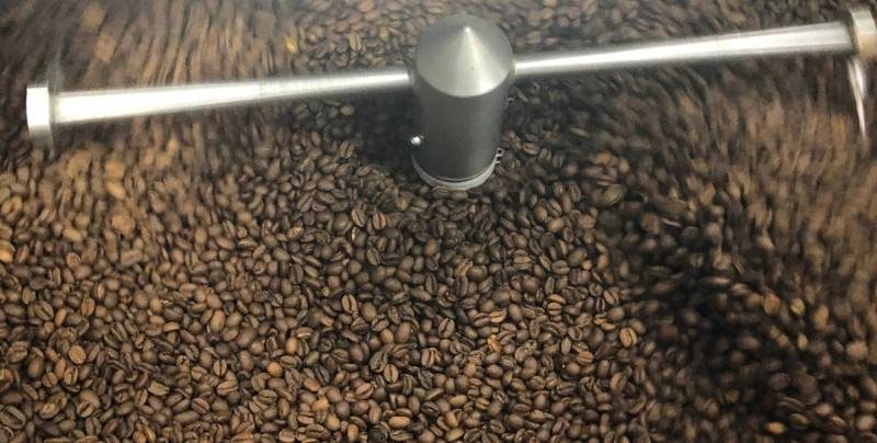 coffee beans spin in a grinder at a cafe